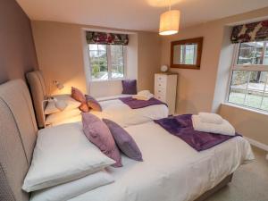 sypialnia z 2 łóżkami i 2 oknami w obiekcie Lavender Cottage w mieście Sedbergh
