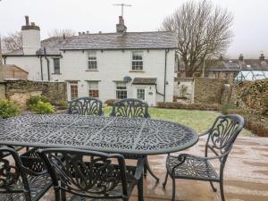 Lavender Cottage في سيدبرغ: طاولة سوداء وكراسي أمام المنزل