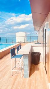 a balcony with a table and chairs on a roof at Vista mar farol da Barra in Salvador