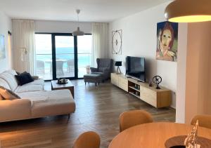 a living room with a couch and a tv and a table at Bliss on the Bay in Njivice
