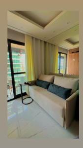 a living room with a couch and a table at Vista mar farol da Barra in Salvador +5 photos