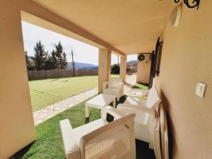 porche con sillas blancas y vistas a un campo en Spa los Balcones, en Loranca de Tajuña