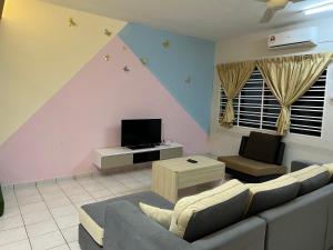 a living room with a couch and a tv at Seri Manjung HomeStay @Spacious Family Home in Seri Manjung