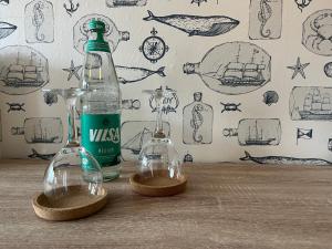 新哈林格西爾的住宿－Pension Blaue Nordseewelle，两杯空酒杯和一张桌子上的瓶子