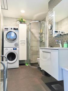 a bathroom with a washing machine and a washer at Scandian Apartments - City Park Tallinn in Tallinn