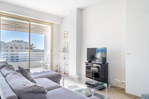 sala de estar con sofá y TV en Palm beach- Free Wifi- Parking- Sea View, en Cannes