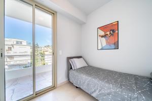 1 dormitorio con cama y ventana grande en Palm beach- Free Wifi- Parking- Sea View, en Cannes