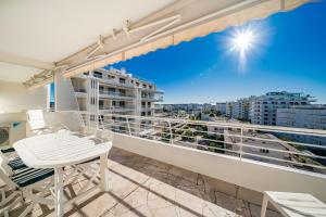 balcón con mesa, sillas y vistas a la ciudad en Palm beach- Free Wifi- Parking- Sea View, en Cannes