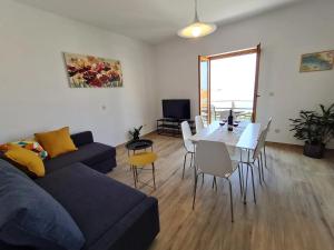 ein Wohnzimmer mit einer Couch und einem Tisch mit Stühlen in der Unterkunft Apartment Stella in Mlini