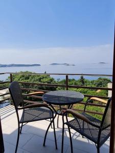 ein Tisch und Stühle auf einem Balkon mit Blick auf das Meer in der Unterkunft Apartment Stella in Mlini