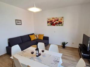 ein Wohnzimmer mit Sofa, Tisch und Stühlen in der Unterkunft Apartment Stella in Mlini