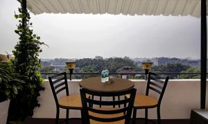 einen Tisch und Stühle auf einem Balkon mit Aussicht in der Unterkunft Treebo Trend Prime Elight in Neu-Delhi