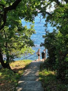 zwei Menschen laufen einen Weg in der Nähe des Wassers entlang in der Unterkunft Apartment Stella in Mlini