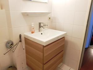 ein weißes Waschbecken im Bad mit weißen Fliesen in der Unterkunft Ferienwohnung 5 im Strandhaus Lobbe in Lobbe + 19 Fotos