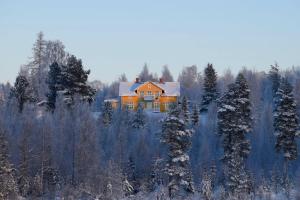 an orange house in the middle of a snowy forest at Kronlund Kursgård in Vindeln