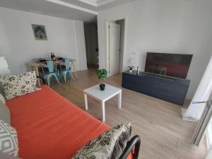 salon z kanapą, telewizorem i stołem w obiekcie Cerca de todo piscina terraza wifi w mieście Tarifa