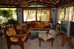 a living room with a couch and a tv at Pousada Agua Marinha in Imbassai