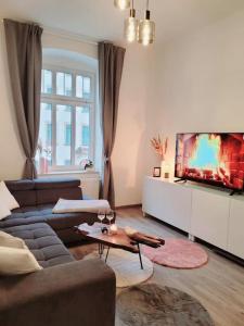 ein Wohnzimmer mit einem Sofa und einem Flachbild-TV in der Unterkunft Daheim in Dresden in Dresden