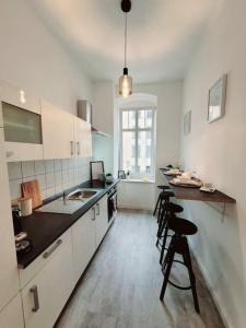 a kitchen with white cabinets and a black counter top at Daheim in Dresden in Dresden