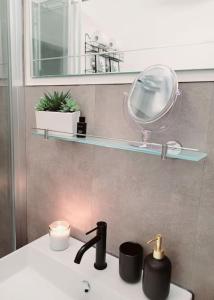 ein Bad mit einem Waschbecken, einem Spiegel und einem Spiegel in der Unterkunft Daheim in Dresden in Dresden