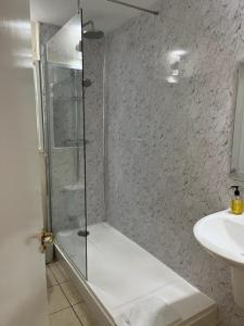 a bathroom with a shower and a sink at The Saracens Head Hotel in Southwell