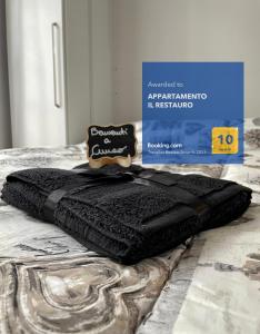 a black blanket sitting on top of a bed at APPARTAMENTO IL RESTAURO in Cuneo