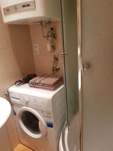 Waschmaschine und Trockner in einem kleinen Bad in der Unterkunft Apartman Fine Rest Brcko in Brčko