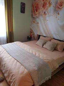ein Schlafzimmer mit einem Bett mit Blumen an der Wand in der Unterkunft Apartman Fine Rest Brcko in Brčko