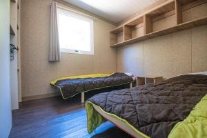 a room with two beds and a window at Camping Cavallo Morto in Bonifacio