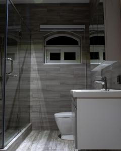1125 City Apartment في آكرا: حمام مع مرحاض ودش زجاجي