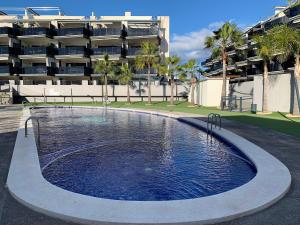 a large swimming pool in front of a building at Realrent Neo Mediterráneo in Barrio-Mar
