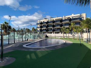 a swimming pool in front of a building at Realrent Neo Mediterráneo in Barrio-Mar