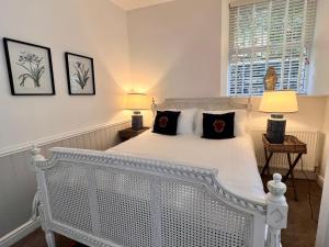 a bedroom with a white bed with two lamps at Rose Cottage at The Stables in Stannington