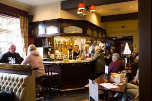 a group of people sitting at a bar in a restaurant at George & Dragon, Conwy in Conwy