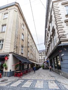 a street in a city with buildings and red chairs at Golden Rose ! Apartments Lviv in Lviv