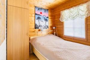 a bedroom with a bed in a wooden room at Countryside riverside cabin for both winter and summer for max 16 persons in Janakkala
