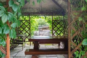 a gazebo with a bench in a garden at Countryside riverside cabin for both winter and summer in Janakkala