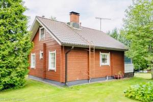 a small wooden house with a grass yard at Countryside riverside cabin for both winter and summer in Janakkala