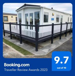a trailer review awards with a black railing and a white caravan at PG177 Golden Palm Resort 8 Berth Caravan With Decking in Chapel Saint Leonards