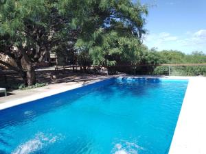 una piscina azul con árboles en el fondo en Complejo Pasos Malos en Merlo