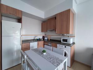 una cucina con frigorifero bianco e armadietti in legno di Apartamento con patio, piscina y parking privado a El Campello