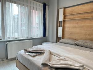 1 dormitorio con 1 cama con cabecero de madera y ventana en beydağı suit, en Estambul