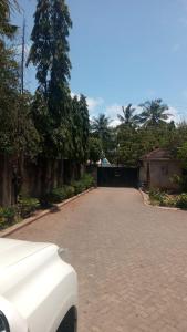 a car parked on a brick road with trees at KITWE PEMBENI APARTMENTS in Mombasa