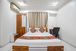 a bedroom with a large bed and a desk at FabHotel Omkar Executive in Pune