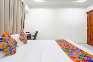 a bedroom with a bed with a colorful blanket at FabHotel Omkar Executive in Pune