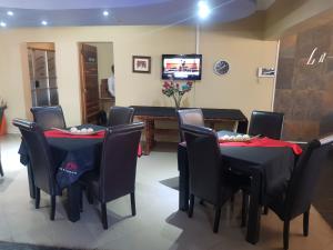 a dining room with black tables and chairs and a television at La Picasso in Ermelo