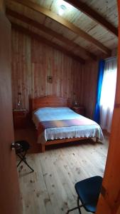 1 dormitorio con 1 cama y suelo de madera en Cabaña Camino al Volcán, en Villarrica