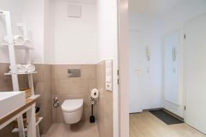 a bathroom with a toilet and a sink at GAR4c Appartementhaus ""Seelust"" in Niendorf +21 photos