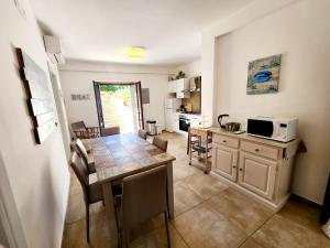 a kitchen and dining room with a table and a microwave at Sperlonga By The Sea in Sperlonga