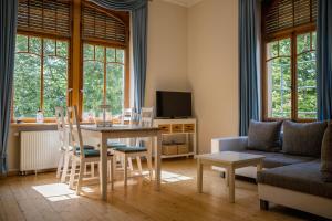 - un salon avec une table, des chaises et un canapé dans l'établissement Grüne Villa Wellness & Spa, à Bad Kreuznach